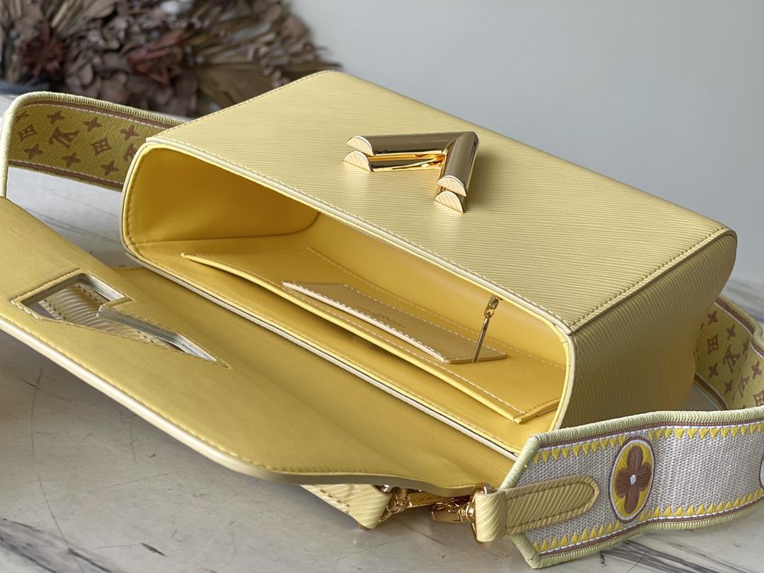 M22036 yellowThis Twist medium size handbag is paired with embroidered fabric shoulder straps