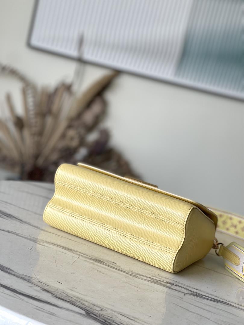 M22036 yellowThis Twist medium size handbag is paired with embroidered fabric shoulder straps