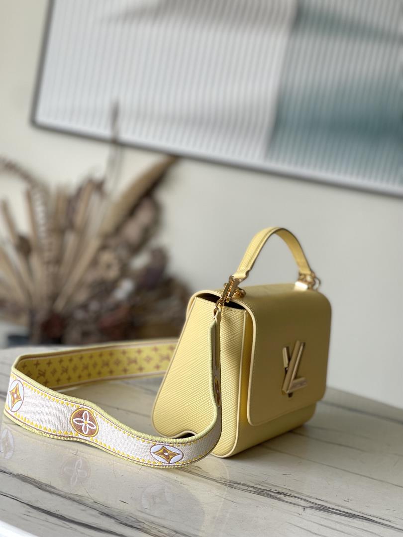 M22036 yellowThis Twist medium size handbag is paired with embroidered fabric shoulder straps