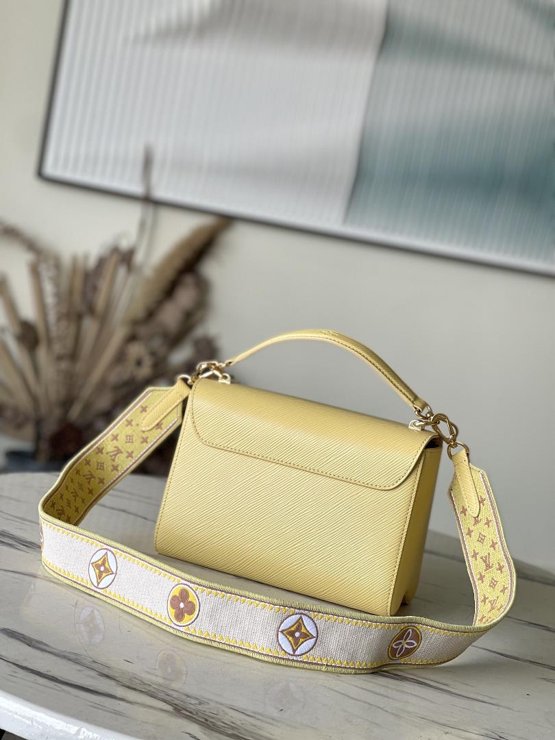 M22036 yellowThis Twist medium size handbag is paired with embroidered fabric shoulder straps
